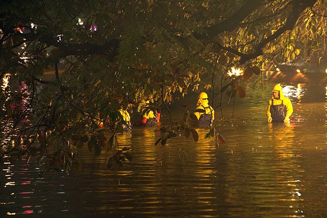 Công nhân dầm mưa lạnh suốt đêm nạo vét Hồ Gươm